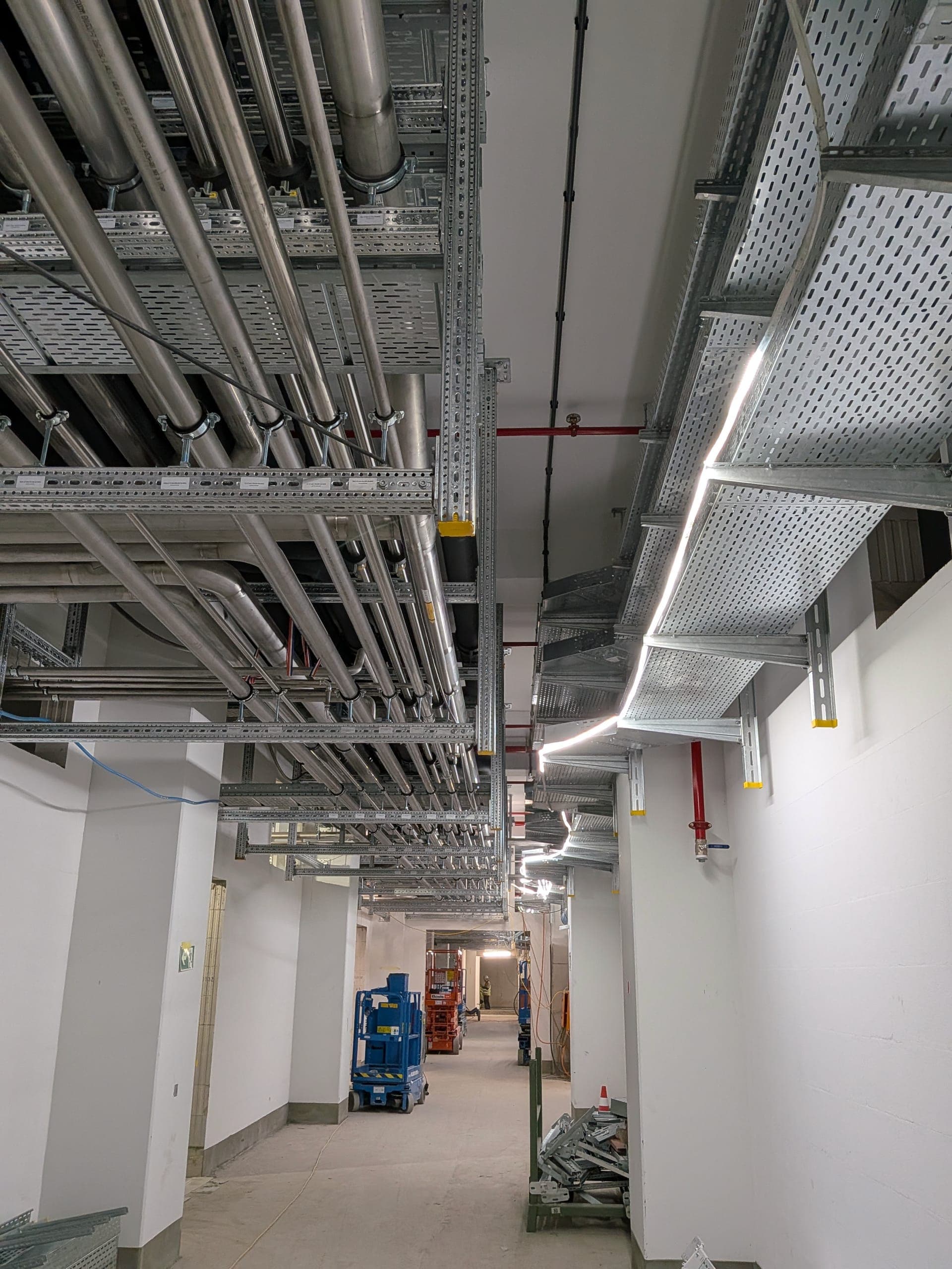 Services corridor with cable trays and piping on site